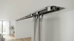 A close-up of ceiling brackets securing a motorised curtain track for bay windows in a modern flat