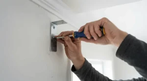 Close-up of a sturdy bracket supporting a heavy-duty motorised curtain track on a plastered wall