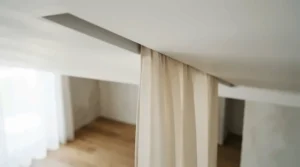 A discreetly recessed motorised curtain track flush with a plasterboard ceiling in a modern extension